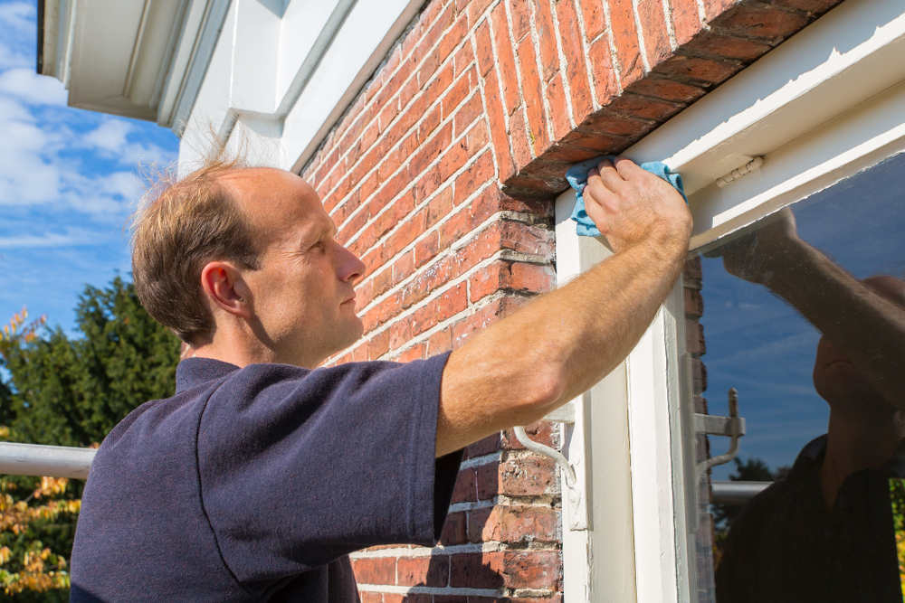 Man cleaning Vinyl Window Frames